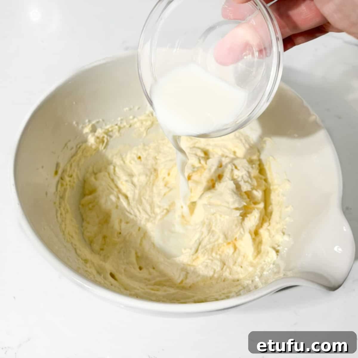 Adding the milk to the Eve's pudding batter.