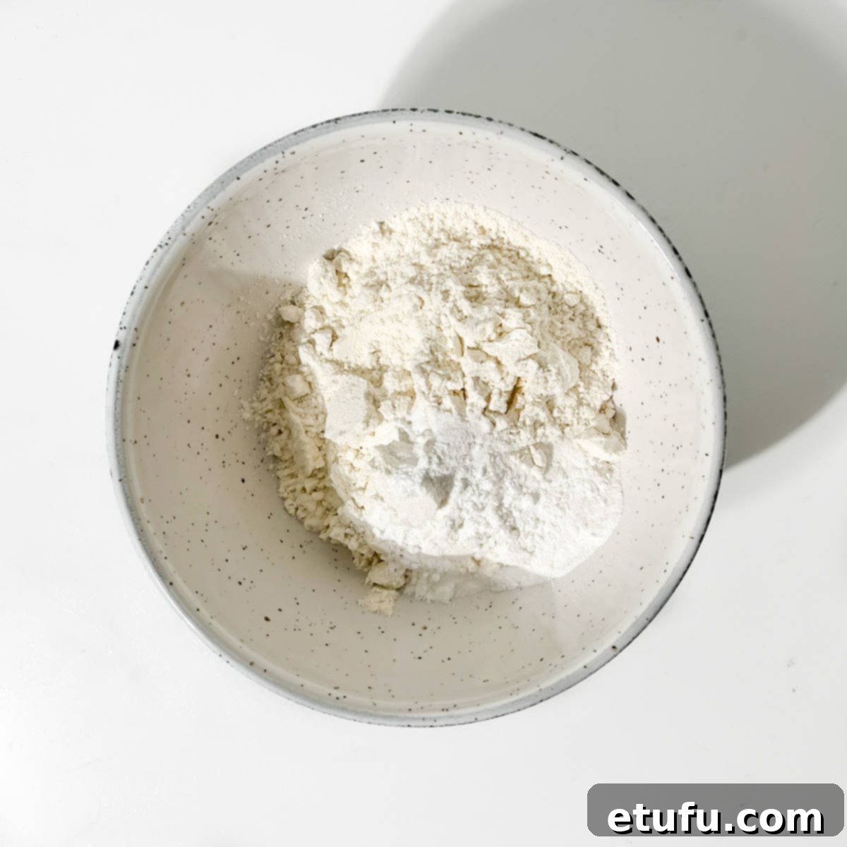 Flour and baking powder in a small white bowl.