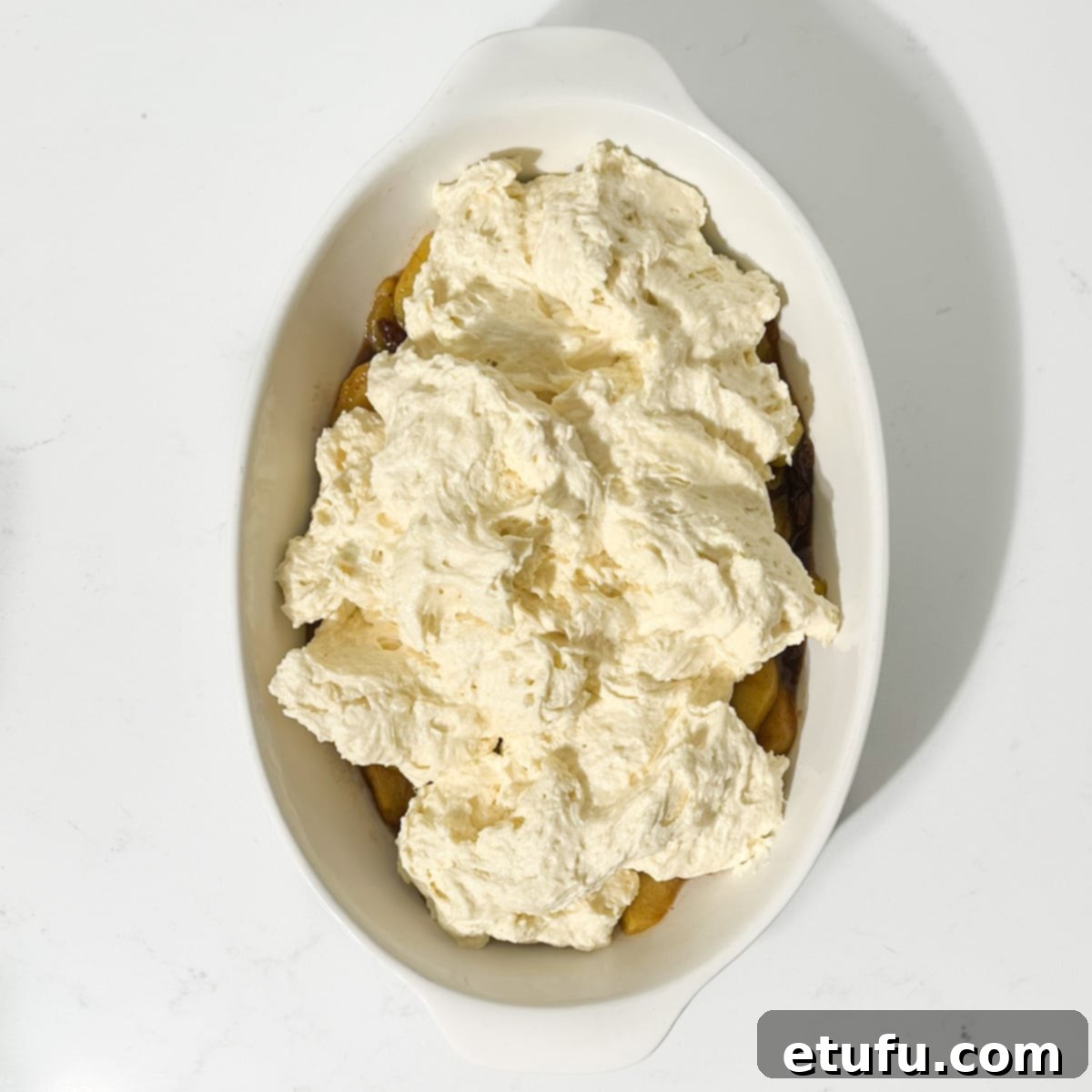 Spooning the batter into the cooked apples.