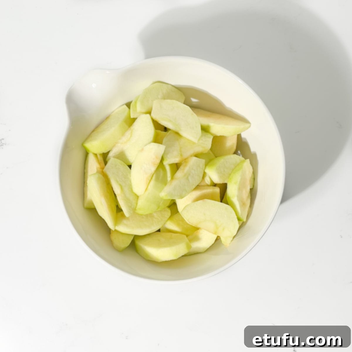 Sliced apples in a white bowl.