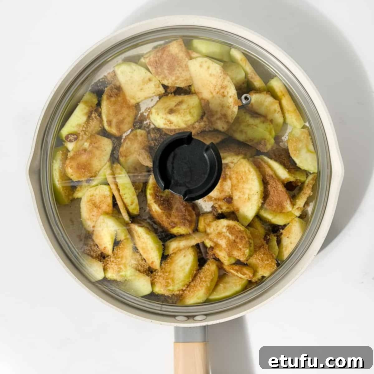 Apples cooking in a large frying pan with the lid on.