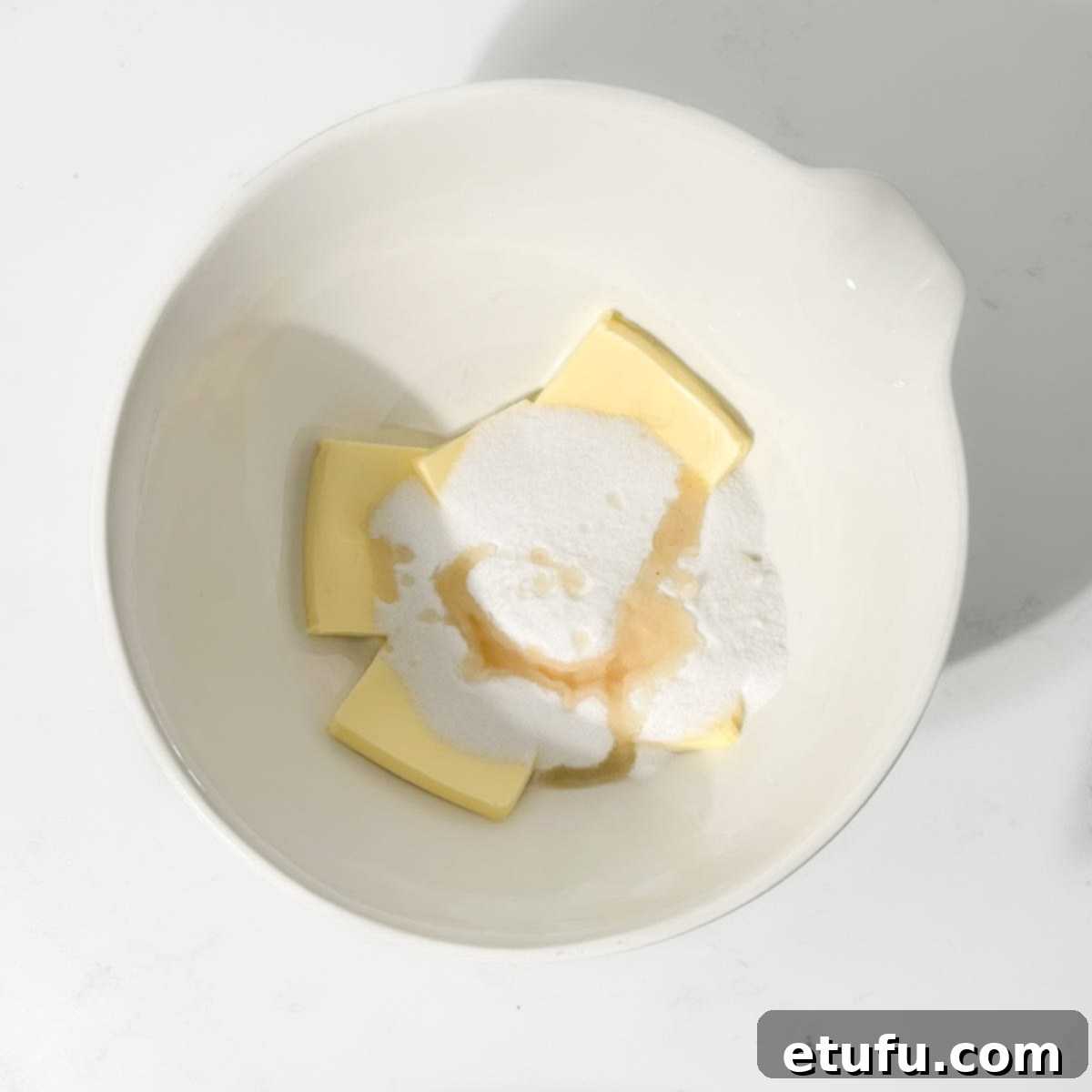 Butter, sugar and vanilla in a large white bowl.