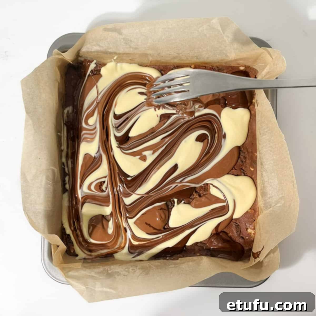 Swirling melted chocolate with a fork.