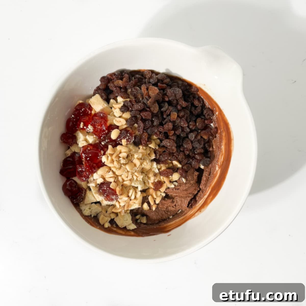 All the ingredients for chocolate tiffin added to a large white bowl.