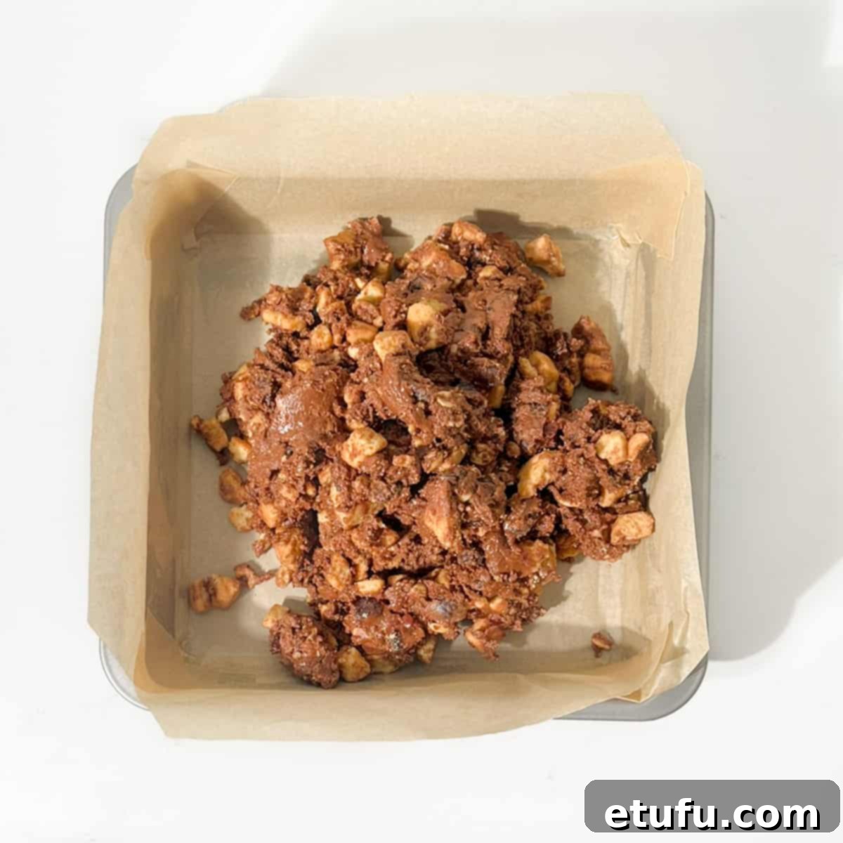 Tiffin mixture tipped into a lined baking dish.