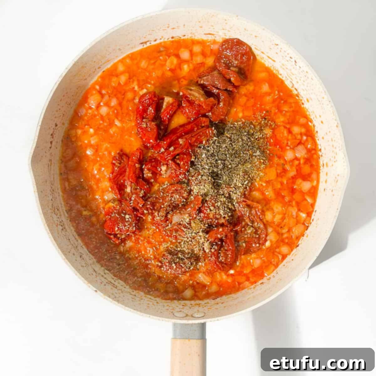 Exquisite Tuscan Marry Me Chicken Pasta 12 Adding the sun-dried tomatoes and herbs to the pan with the onions.