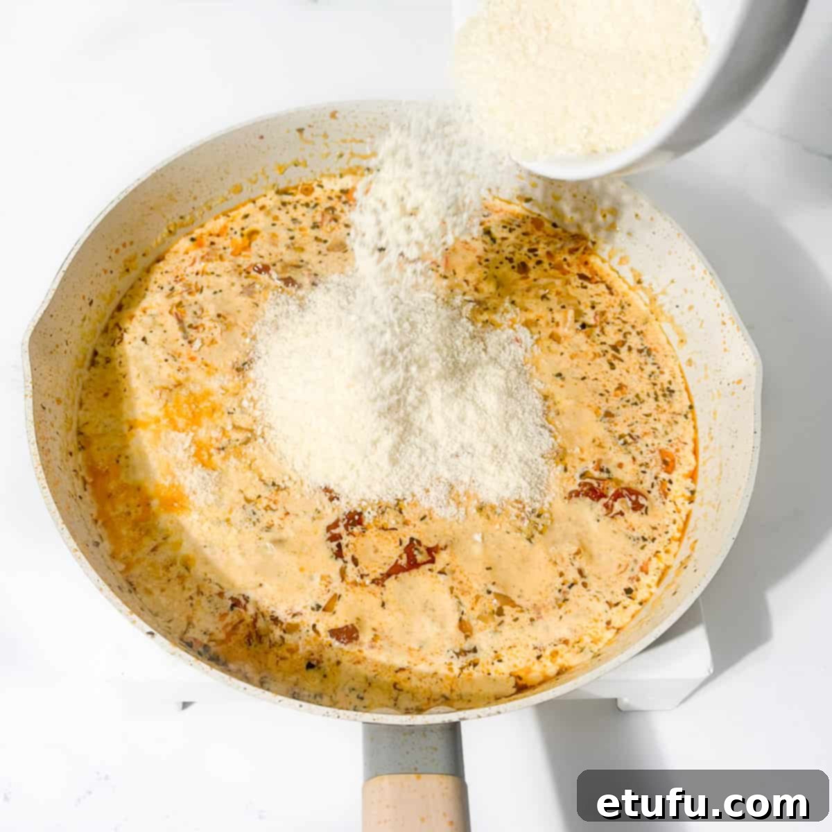 Exquisite Tuscan Marry Me Chicken Pasta 14 Adding the parmesan cheese to the marry me chicken pasta sauce.