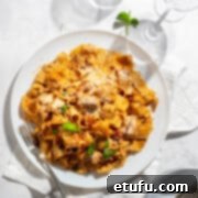 Exquisite Tuscan Marry Me Chicken Pasta 18 Marry me chicken pasta on a large white plate with two wine glasses.