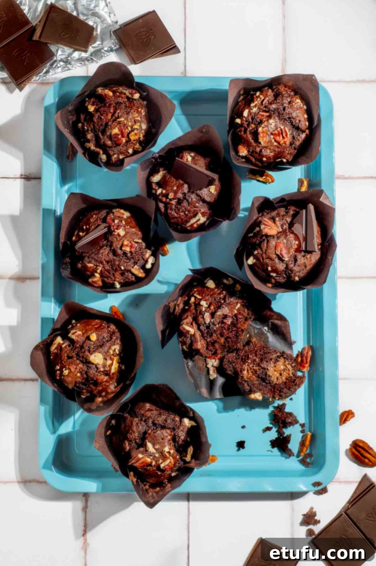 Golden Banana Chocolate Chunk Muffins 2 Banana chocolate chunk muffins on a turquoise baking tray.
