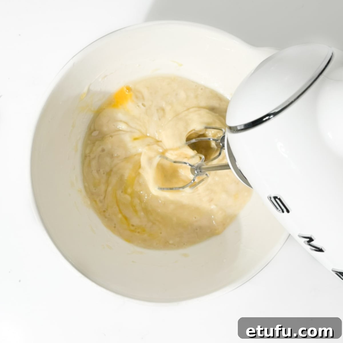 Golden Banana Chocolate Chunk Muffins 11 Beating the eggs into the banana mixture with an electric hand mixer.