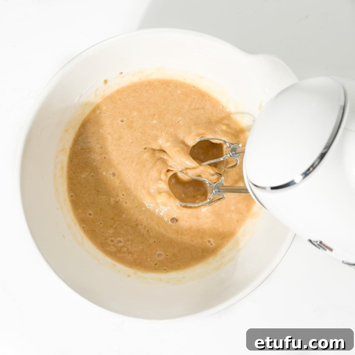 Golden Banana Chocolate Chunk Muffins 13 Beating the brown sugar into the eggs with am electric hand mixer.