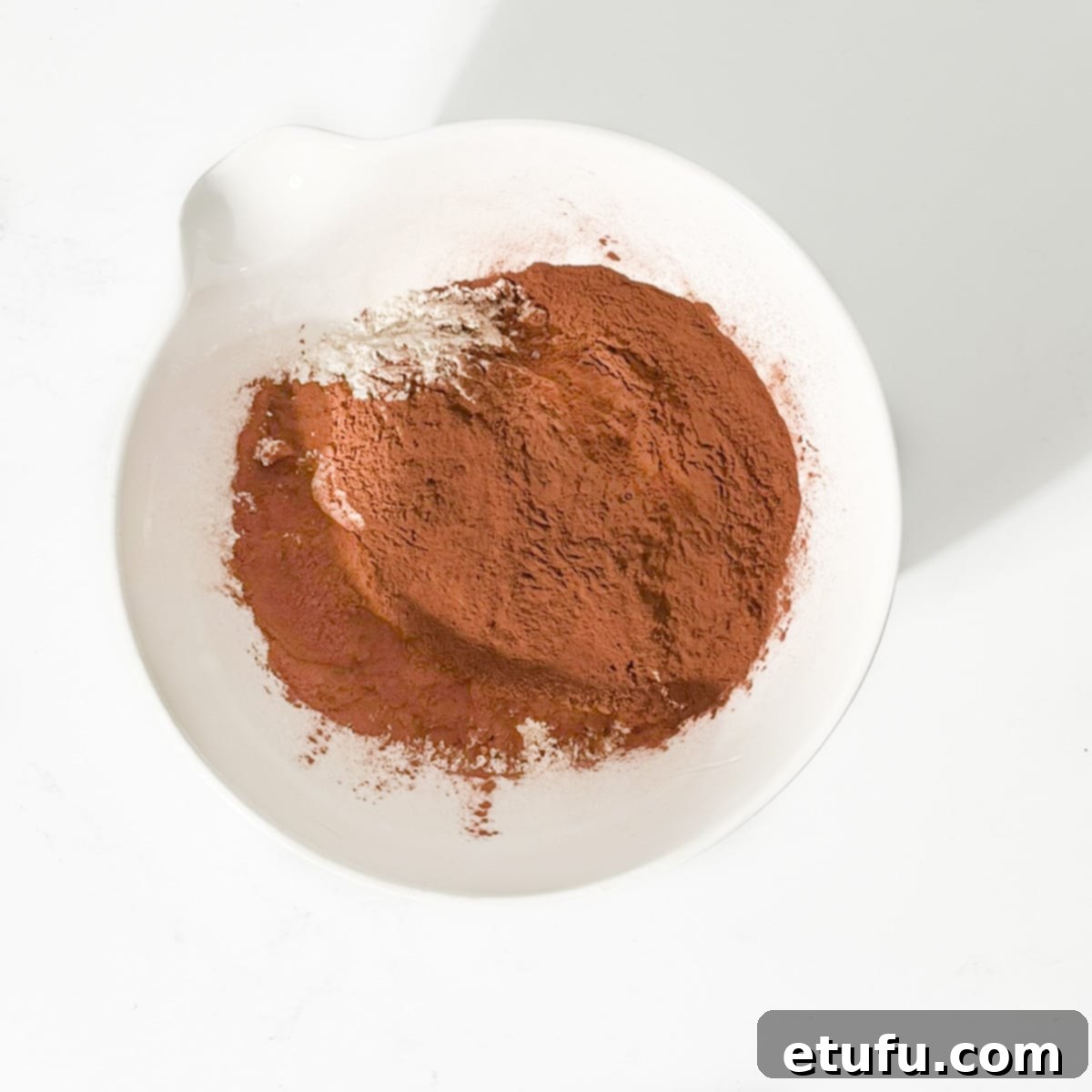 Golden Banana Chocolate Chunk Muffins 14 Adding all the dry ingredients for the Baked banana chocolate chunk muffins to a large white bowl.