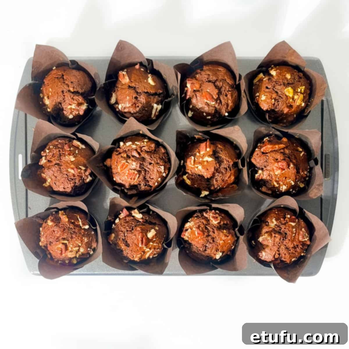 Golden Banana Chocolate Chunk Muffins 20 Baked banana chocolate chunk muffins in a 12-hole muffin baking tray.