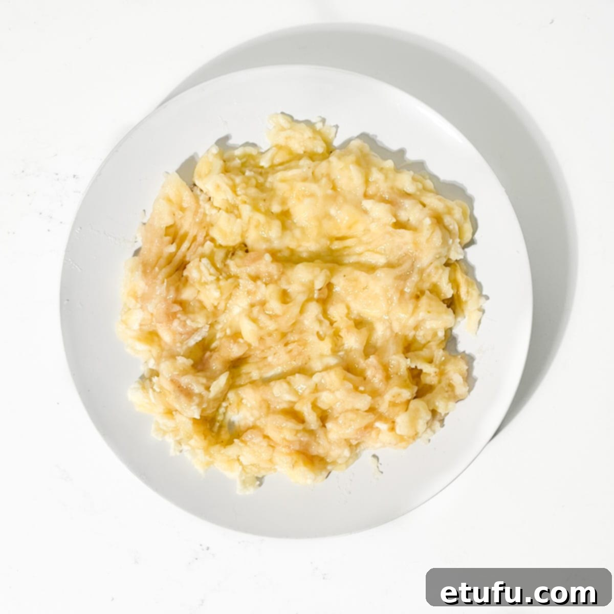 Golden Banana Chocolate Chunk Muffins 7 Mashed banana on a plate.