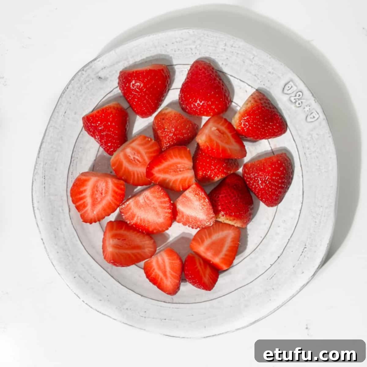 A plate of sliced strawberries.