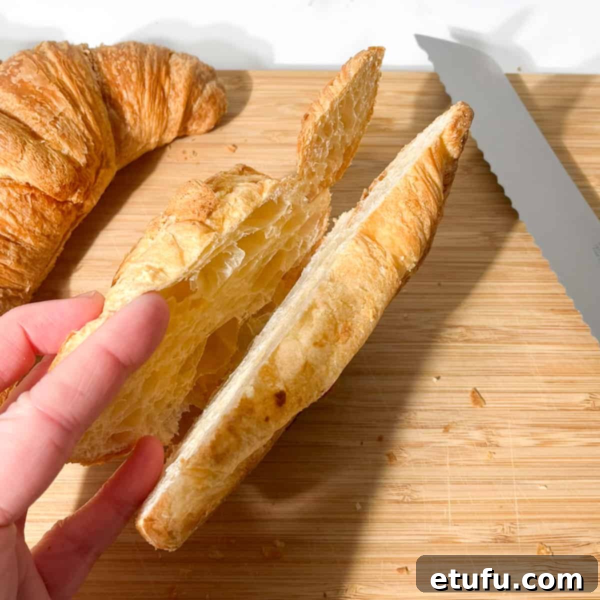 Slicing the croissant half way through.