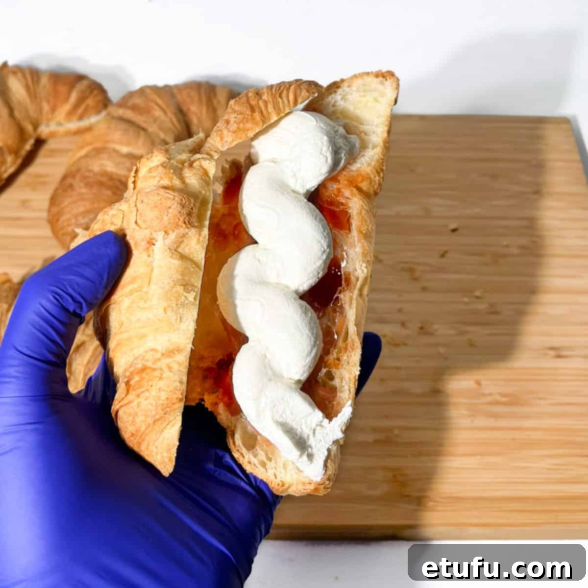 Filling the croissant with the cream.