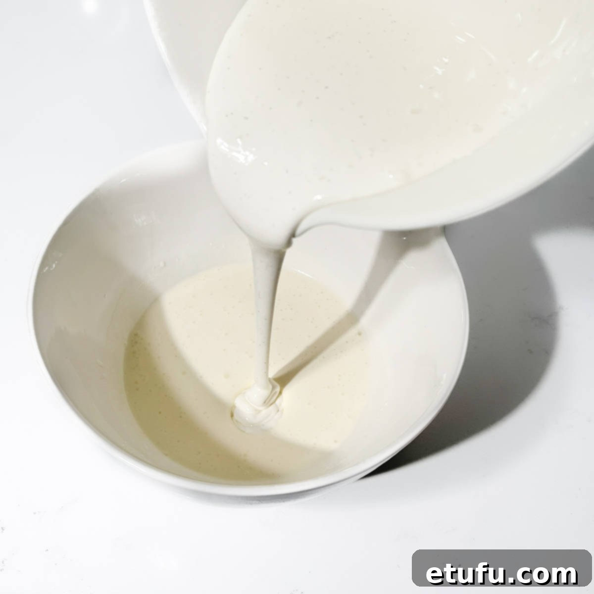 Adding the whipped mascarpone cream to the double cream.