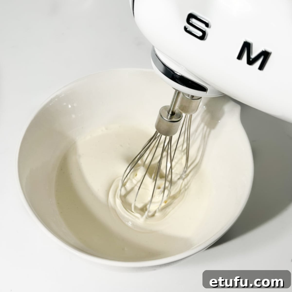 Whipping the cream and mascarpone cheese together.