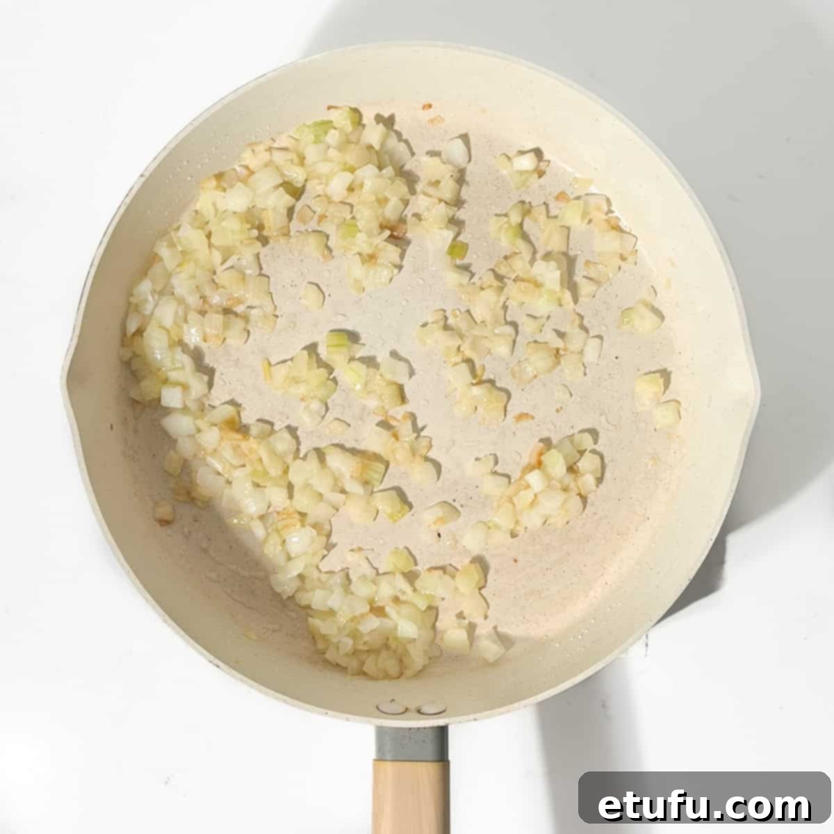 Frying the onions in a large frying pan.