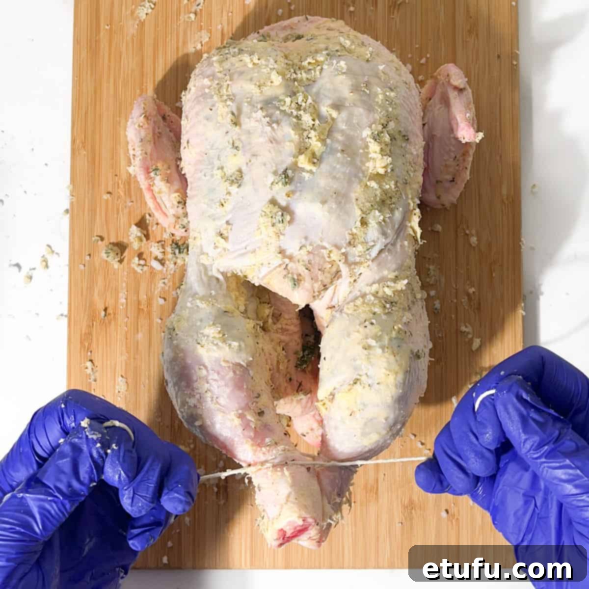 Trussing the chicken legs together with kitchen twine.