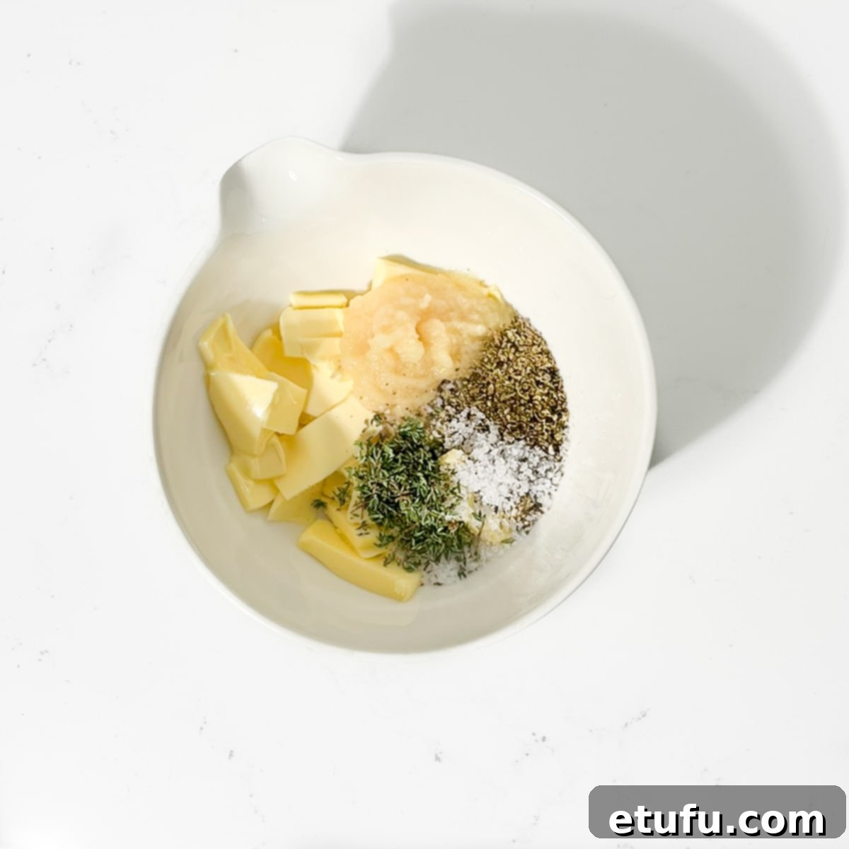 All the ingredients for the compound butter in a small bowl, ready to be mixed.
