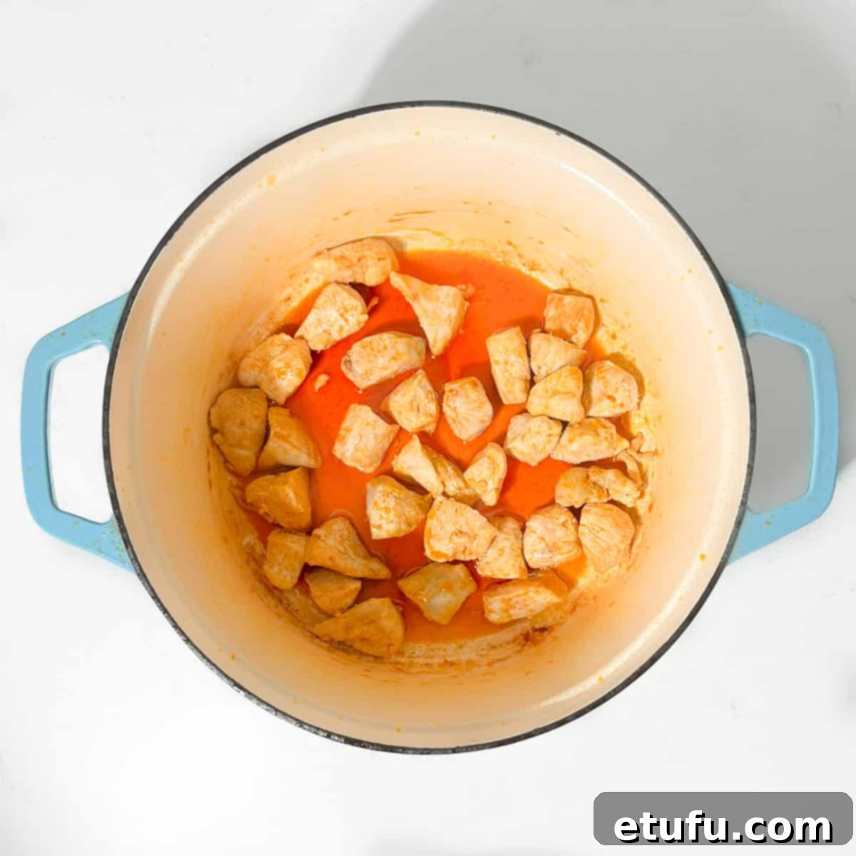 Browning the chicken in the chorizo-infused oil, developing rich flavor.