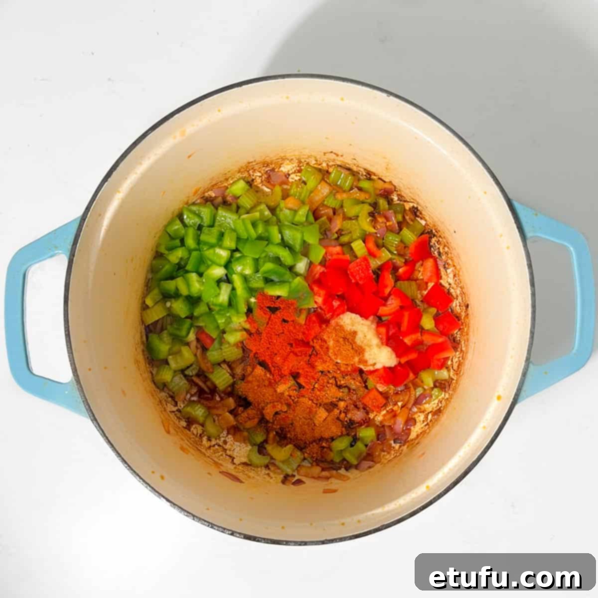 Adding colorful bell peppers and spices to the sautéed onions and celery for the chicken and chorizo jambalaya base.