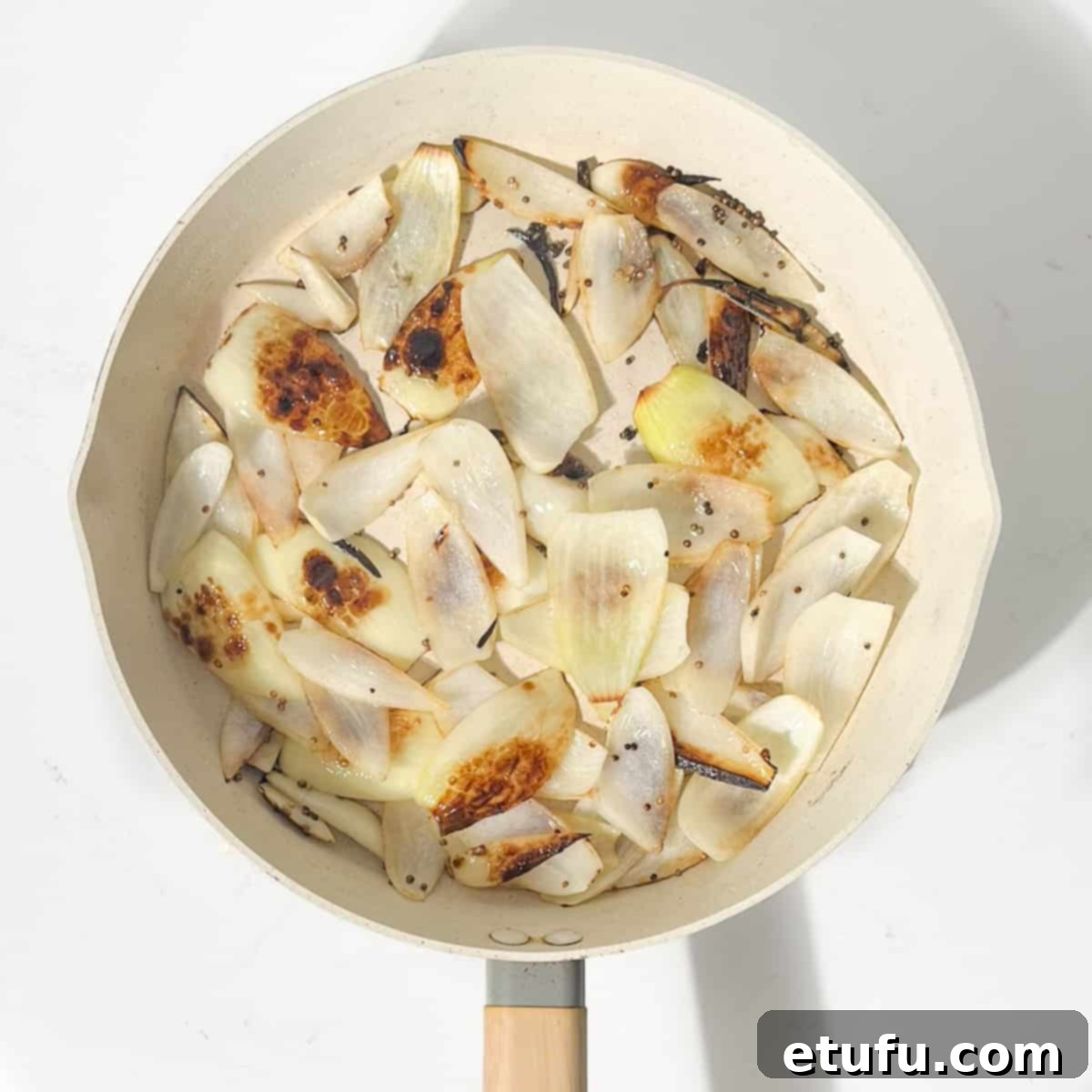 Charring the onion petals in a large frying pan.