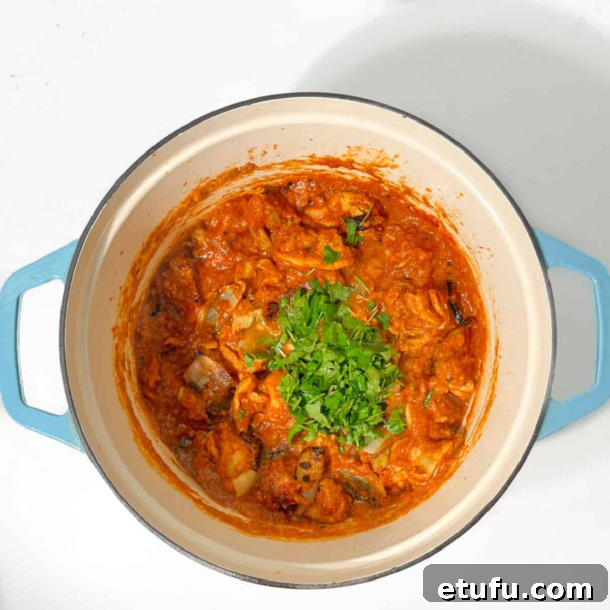 Adding the coriander to the chicken dopiaza.