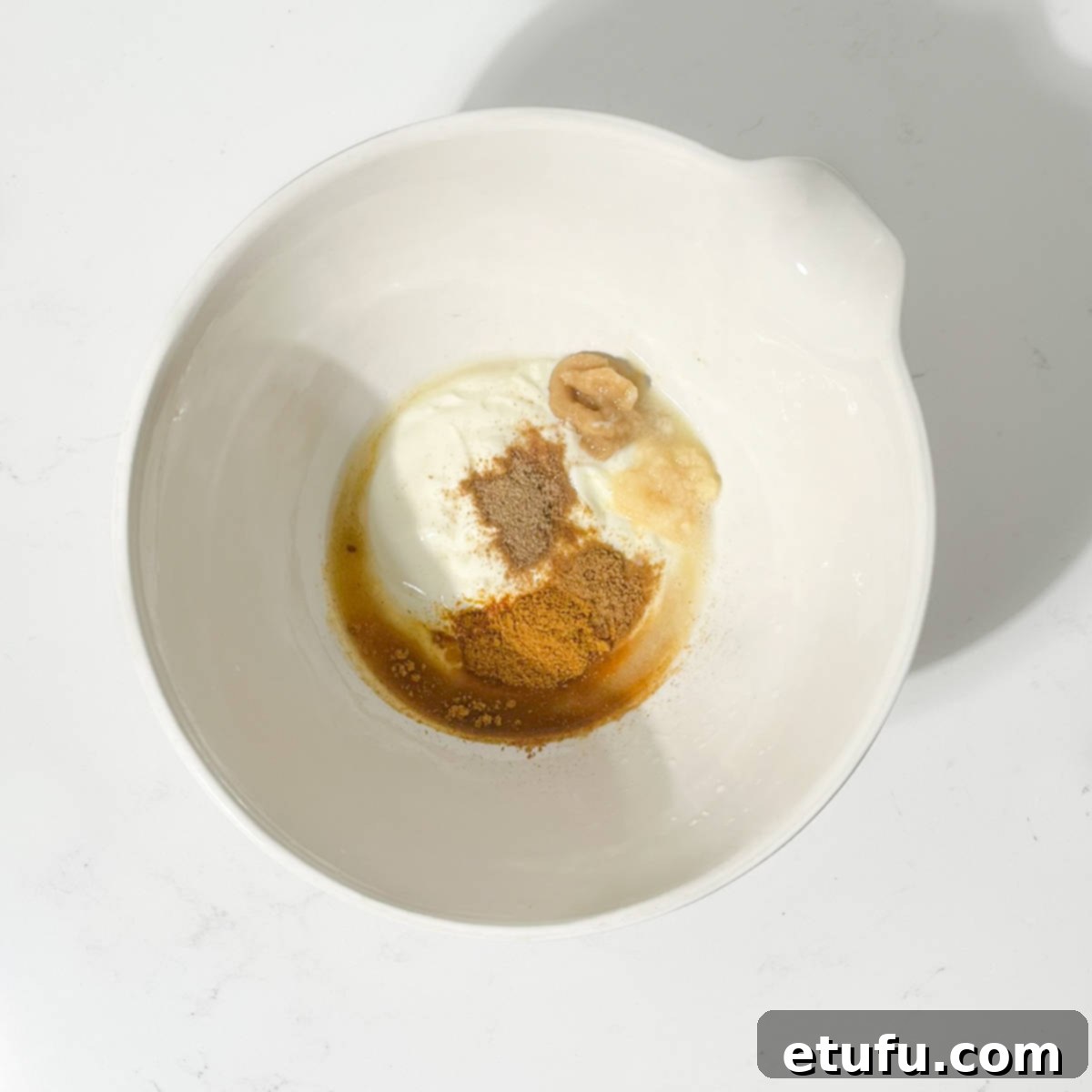 Adding all the ingredients for the chicken do pyaza to a bowl. 