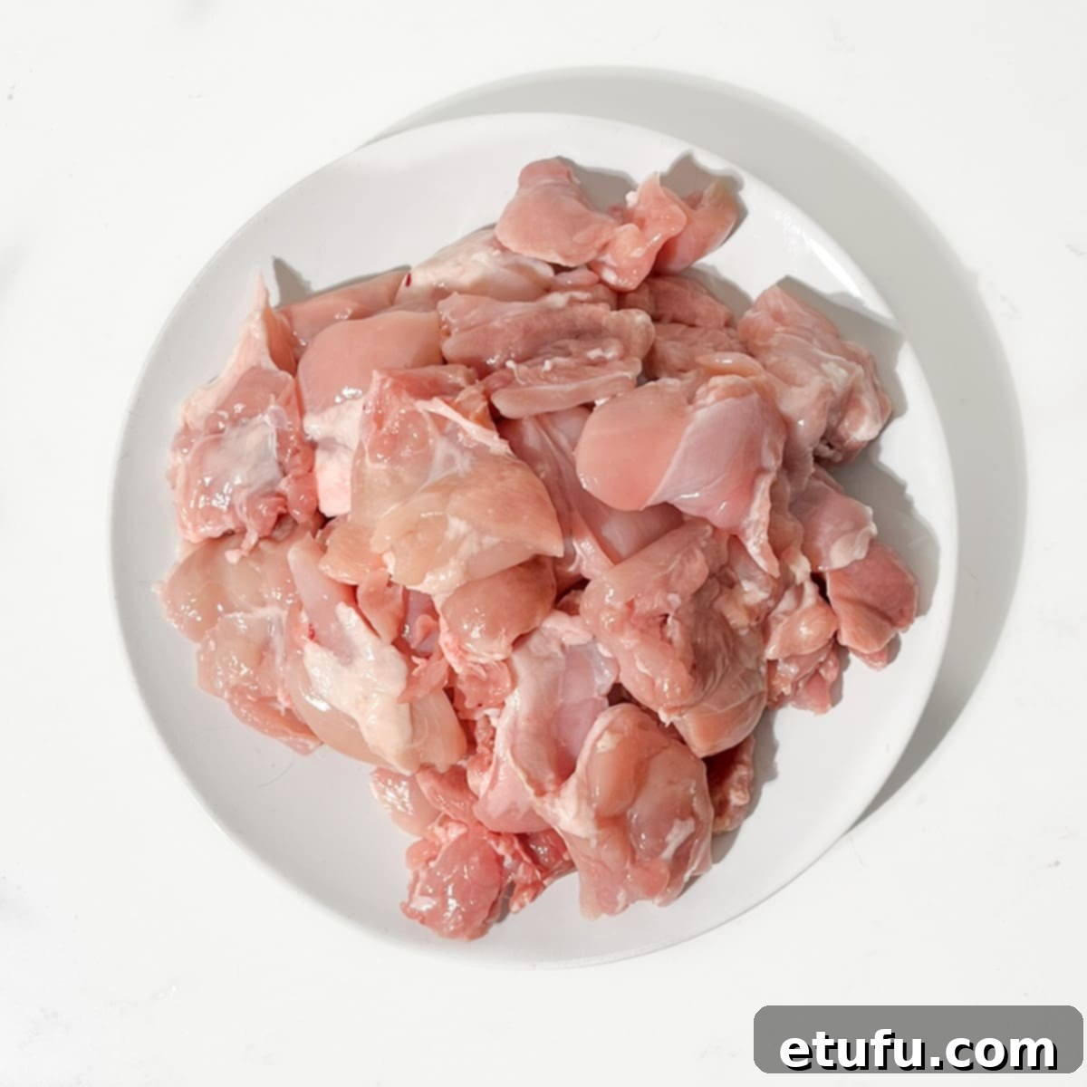 Dicing the chicken thighs into large chunks.