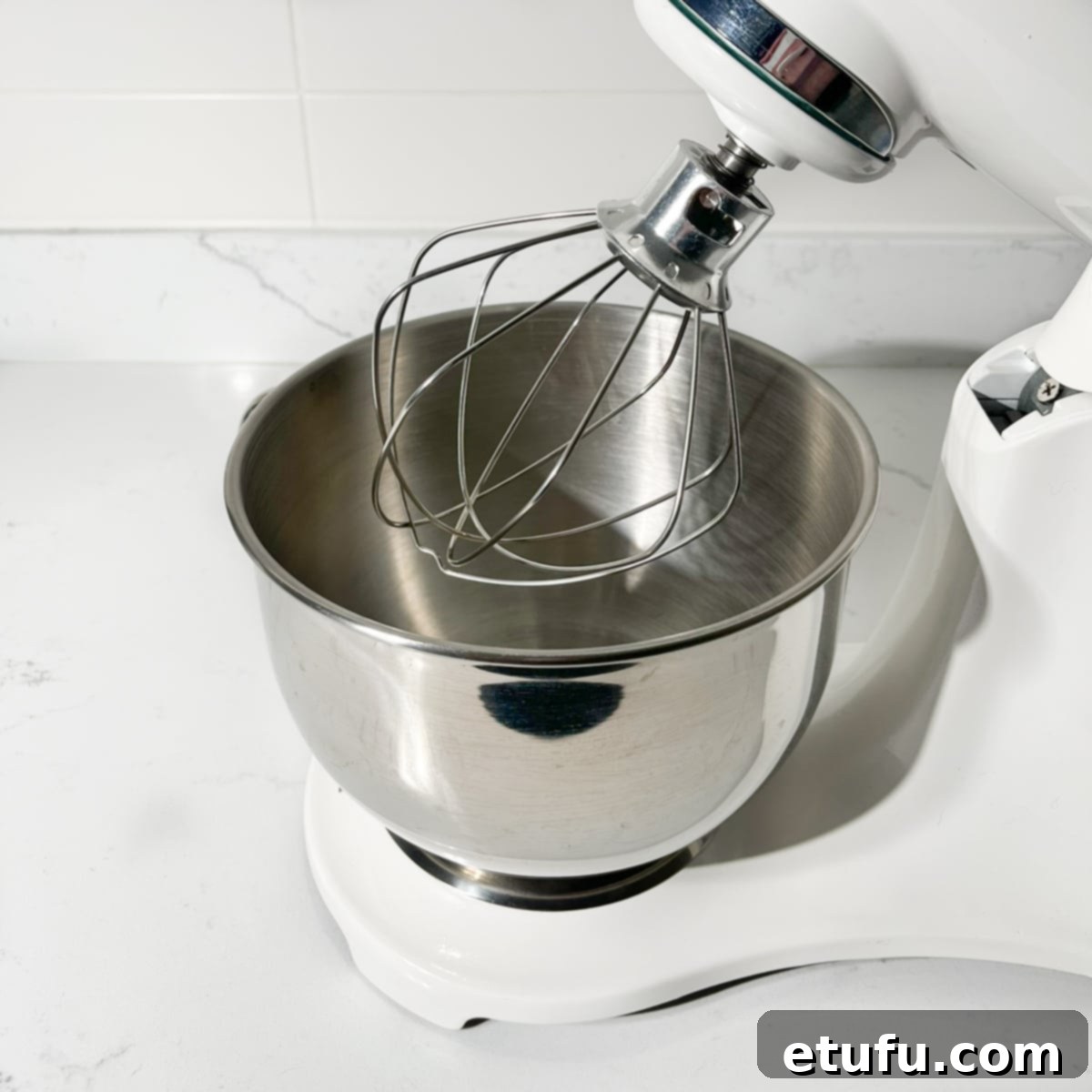 A stand mixer with the whisk attachment ready, positioned for making meringue.