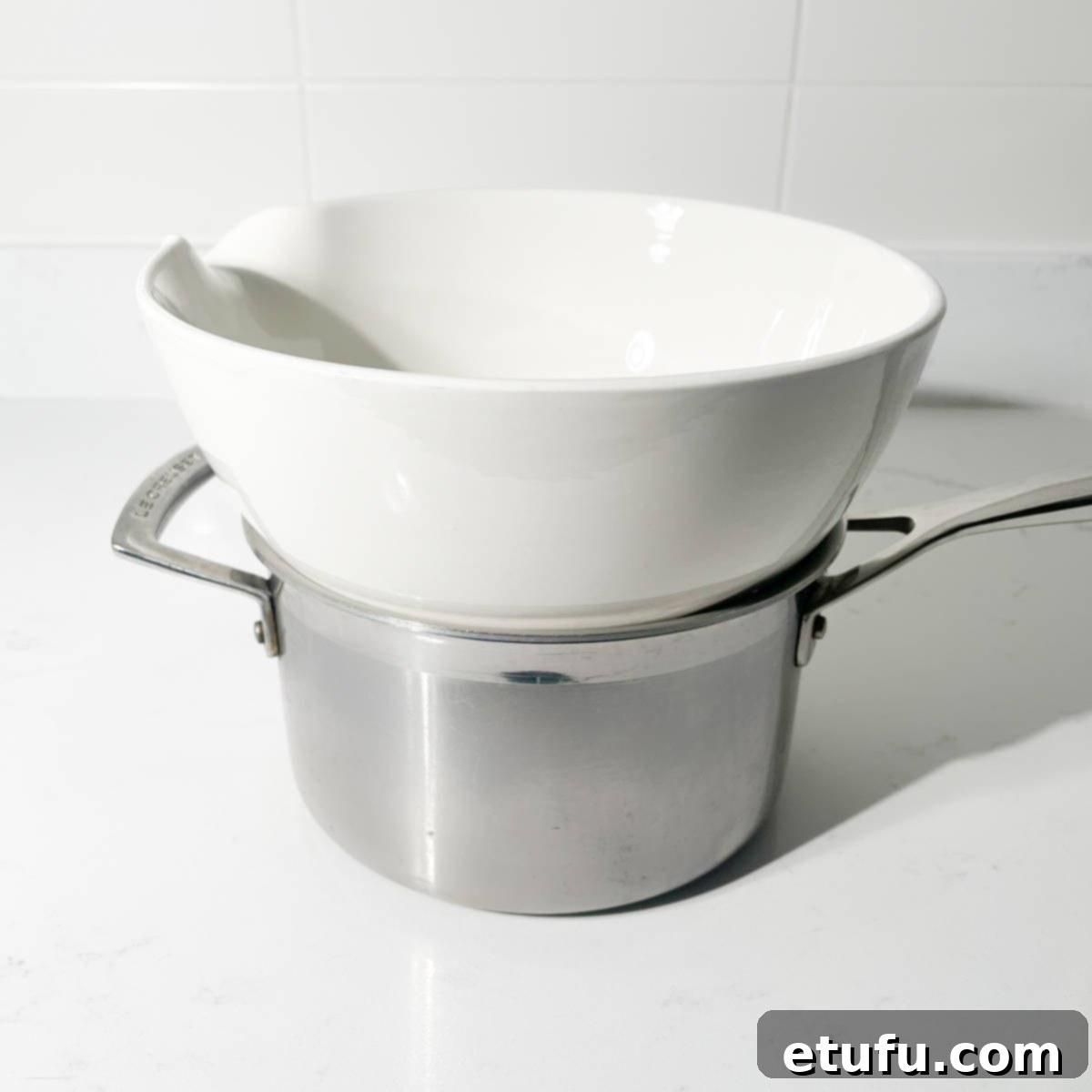 A heatproof bowl resting on top of a saucepan of simmering water, creating a bain-marie.