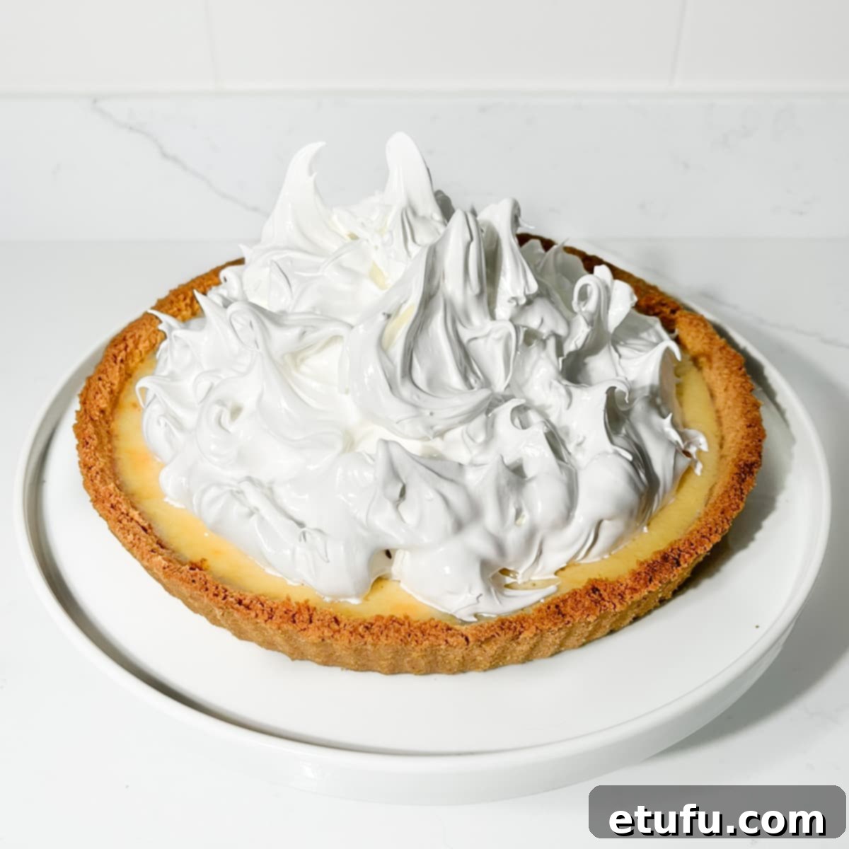 Billowing clouds of Swiss meringue generously spooned on top of the chilled lemon filling, creating a rustic look.
