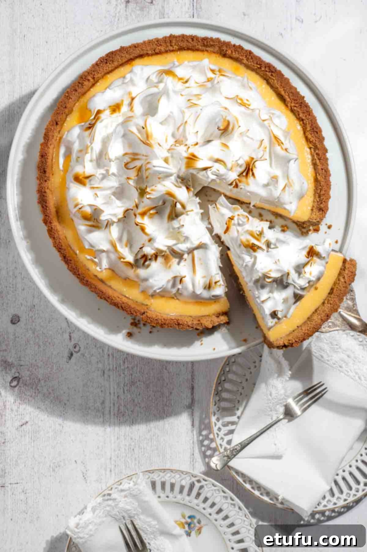 A slice taken from the biscuit base lemon meringue pie, showing its layers.