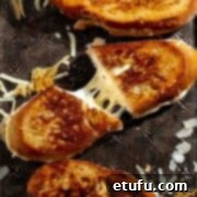 Sourdough grilled cheese sandwich sliced and pulled apart to show melted cheese inside.