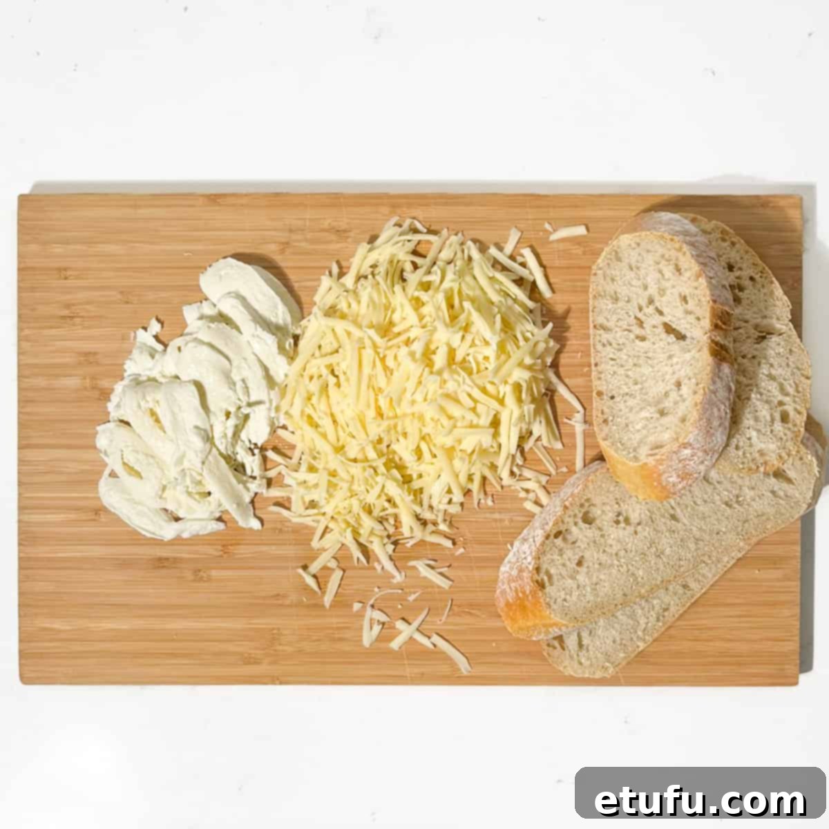 Grated and sliced cheese and bread for the sourdough grilled cheese sandwich.