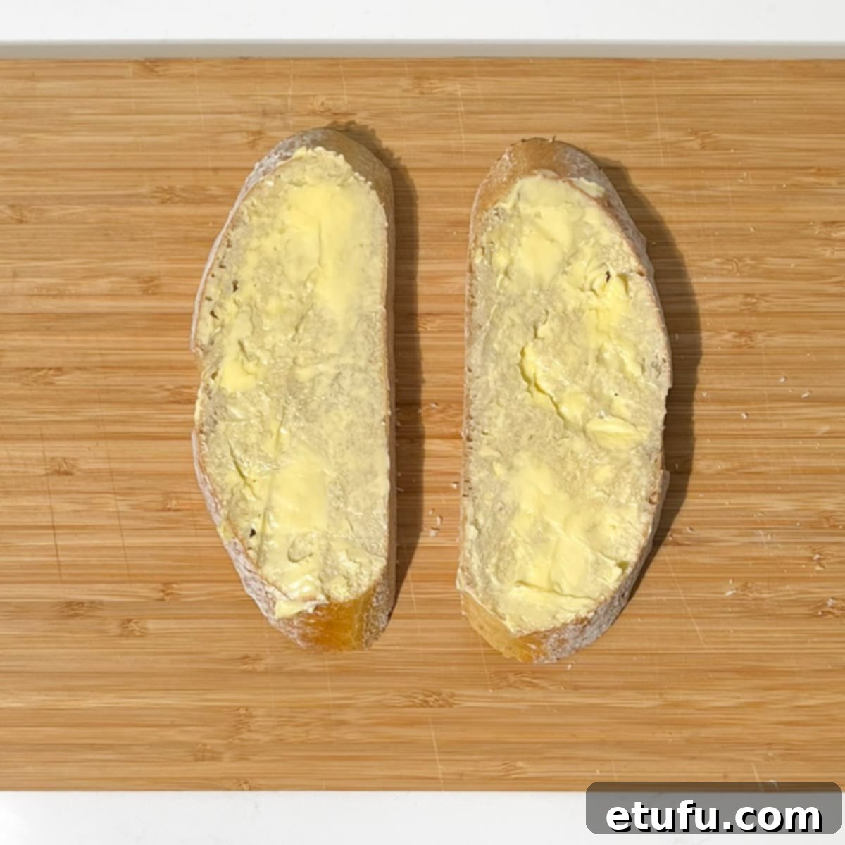 Two slices of buttered bread for the sourdough grilled cheese sandwich.