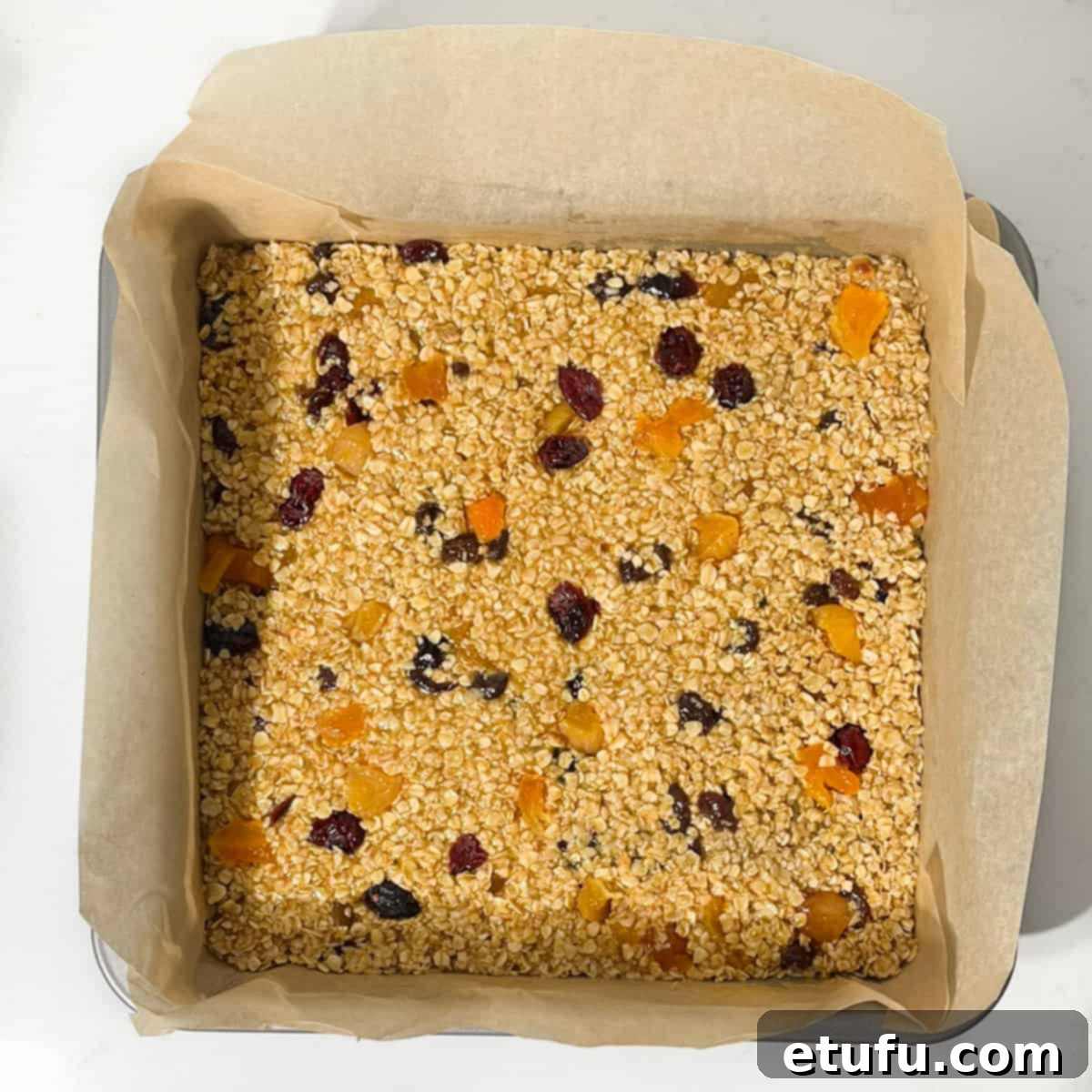 Flapjacks in a lined baking tin ready for the oven.