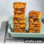 Two stacks of fruity flapjacks on a green baking tray.