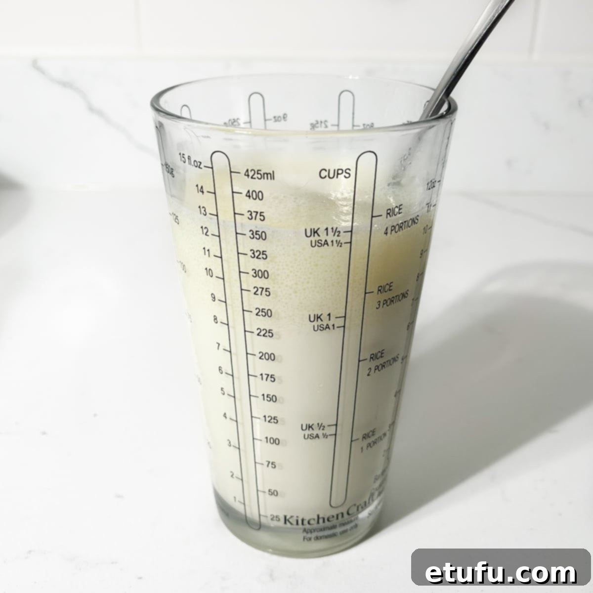 Mixing lukewarm milk and neutral oil in a measuring jug.