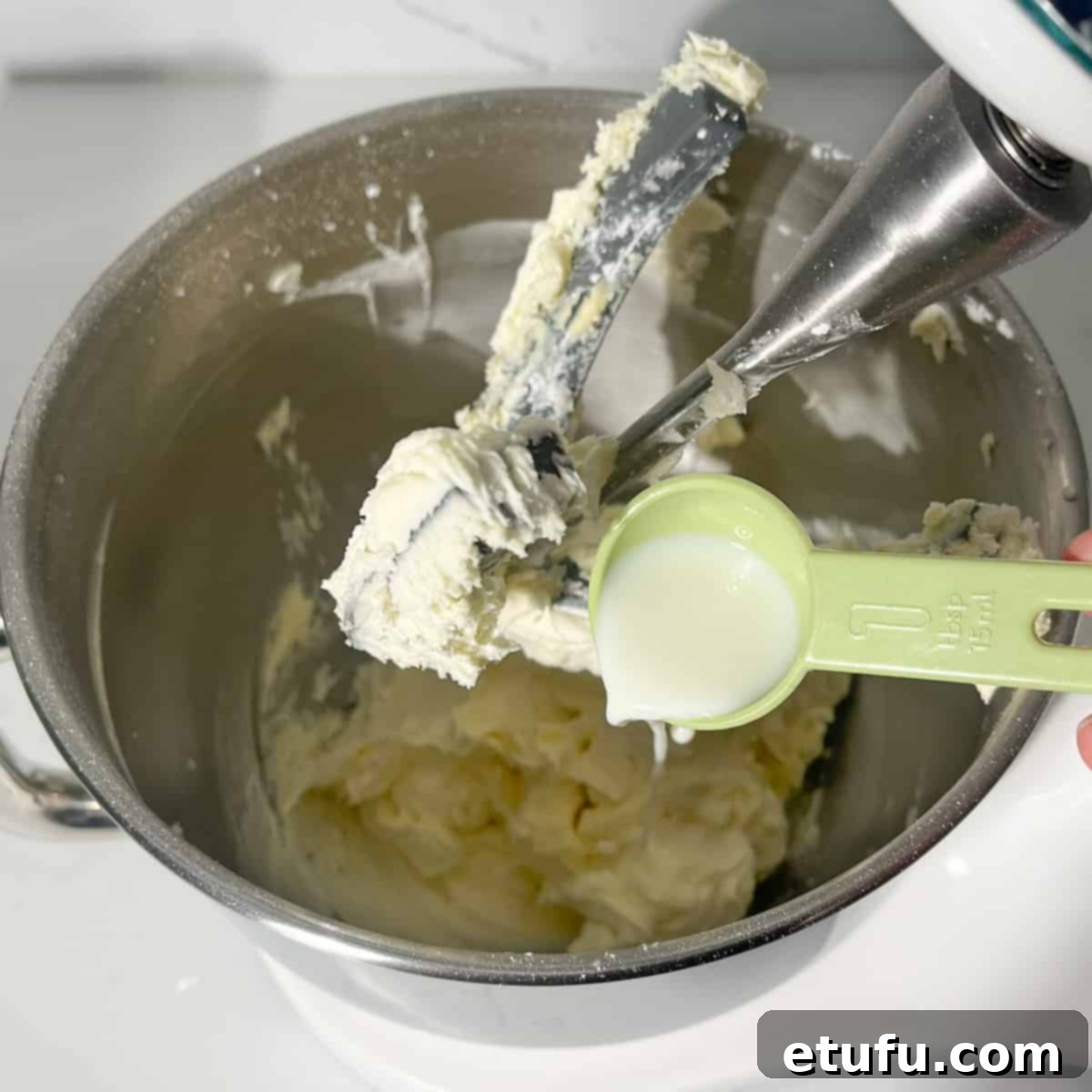 Adding a splash of milk to the buttercream to achieve desired consistency.