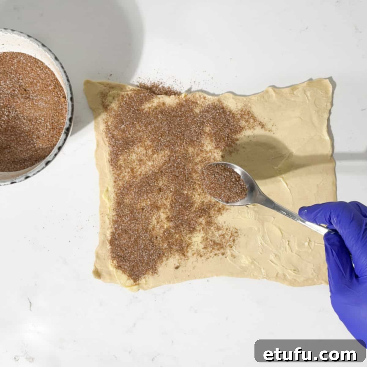 Sprinkling the cinnamon sugar onto the butter.