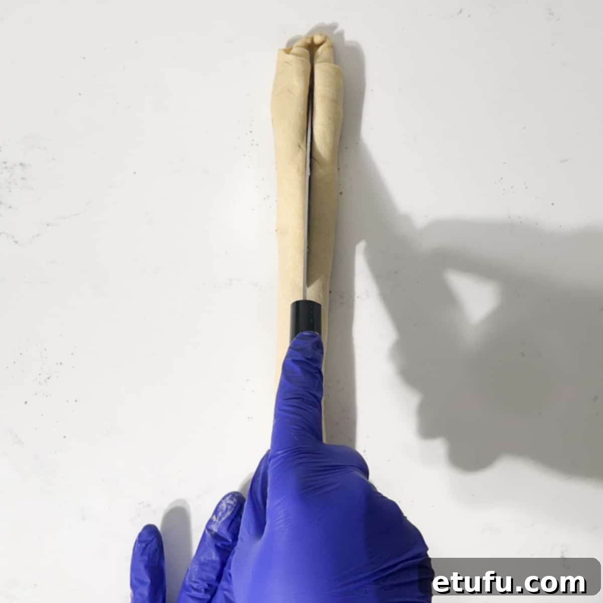 Slicing the dough sausage in half lengthways.