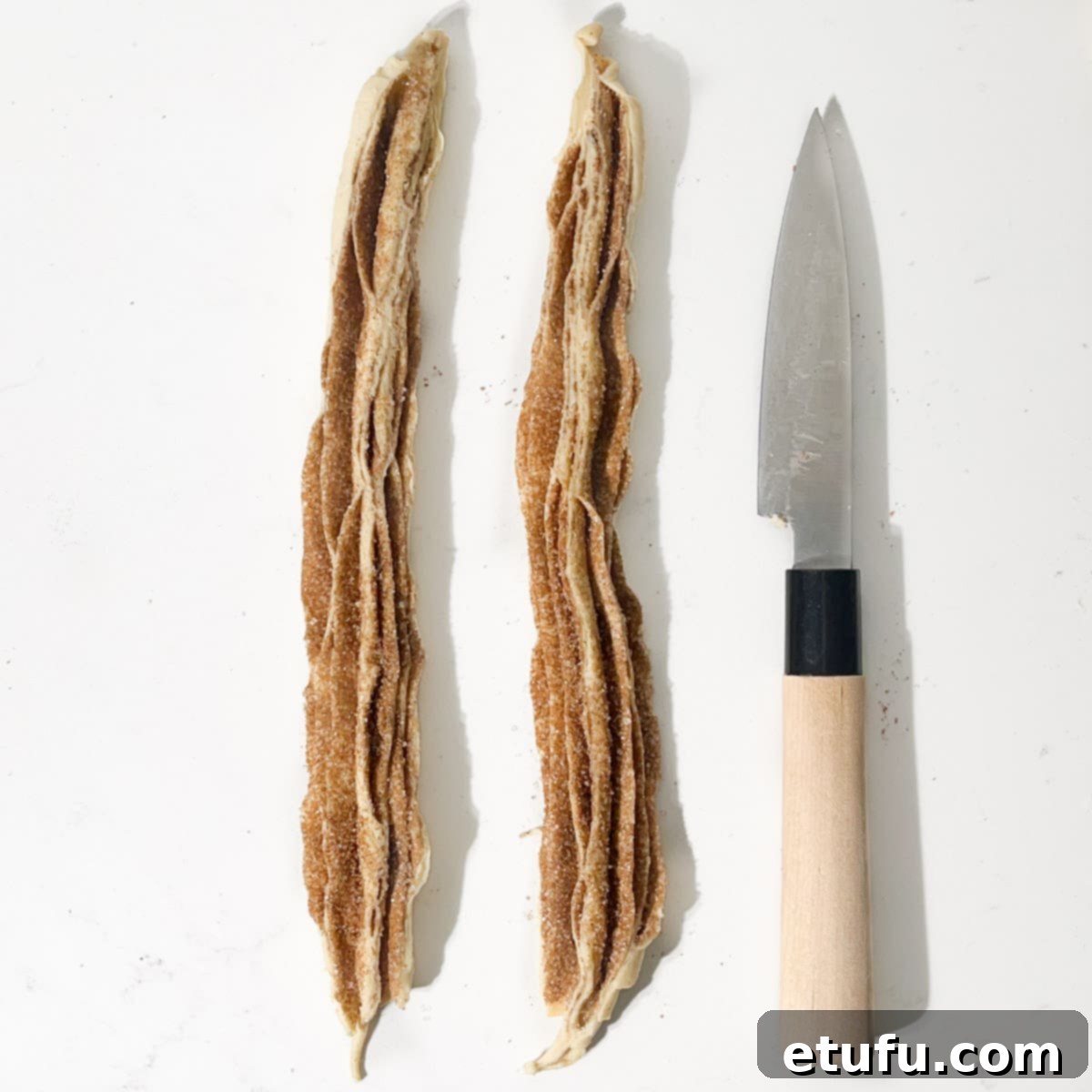 Two strips of dough sausage after the cutting the sausage in half.