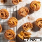 Cruffins scattered on a white background sprinkled with cinnamon sugar.