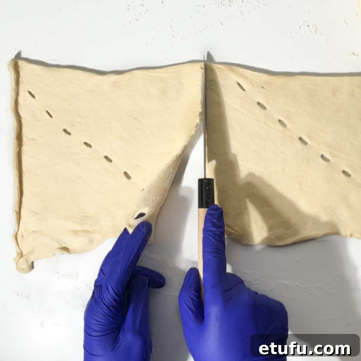 Cutting the croissant dough into squares.