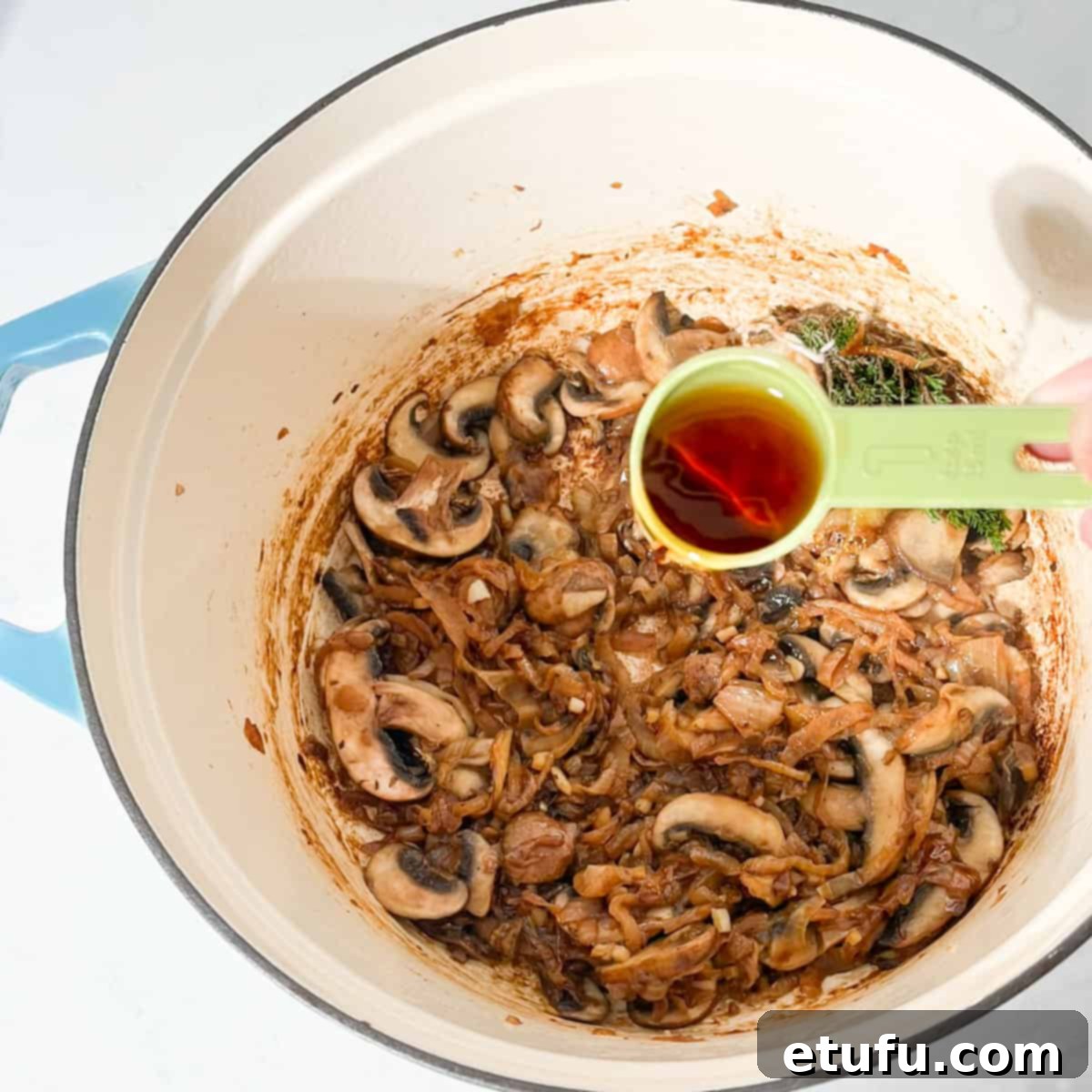 Adding sherry to onions and mushrooms.