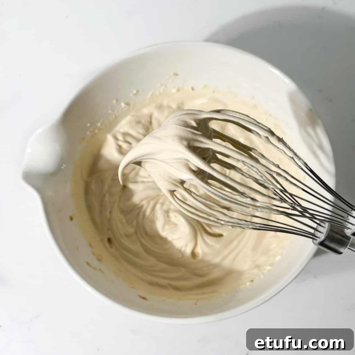 Demonstrating soft peaks on the mascarpone cream.